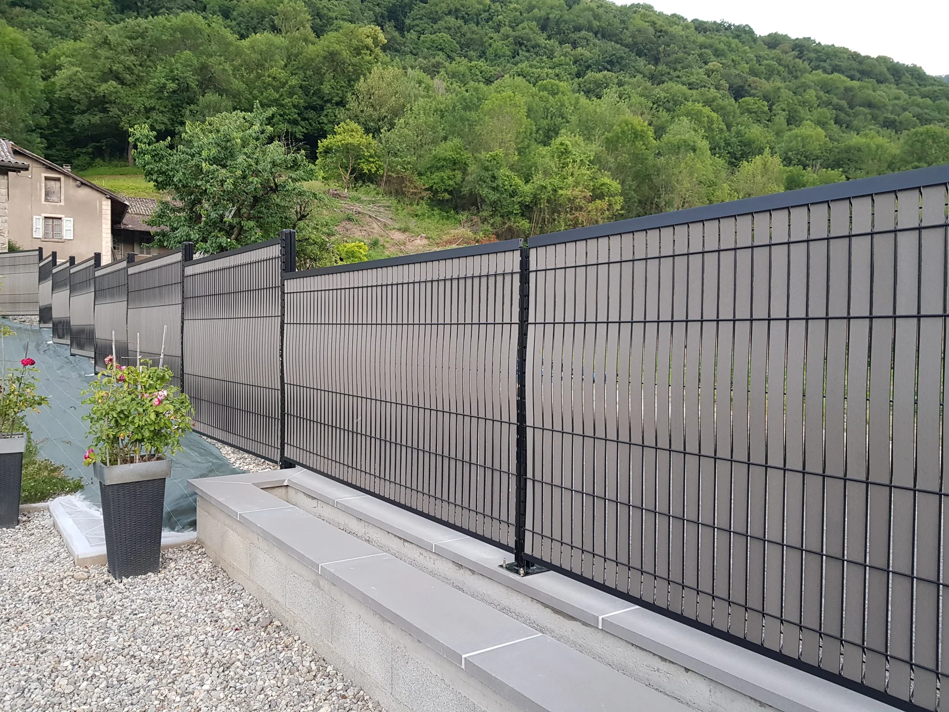 Cloture composite tressee gris beton paysage montagne